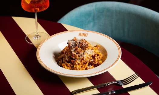 Bowl of pasta on striped table at JUNO London.