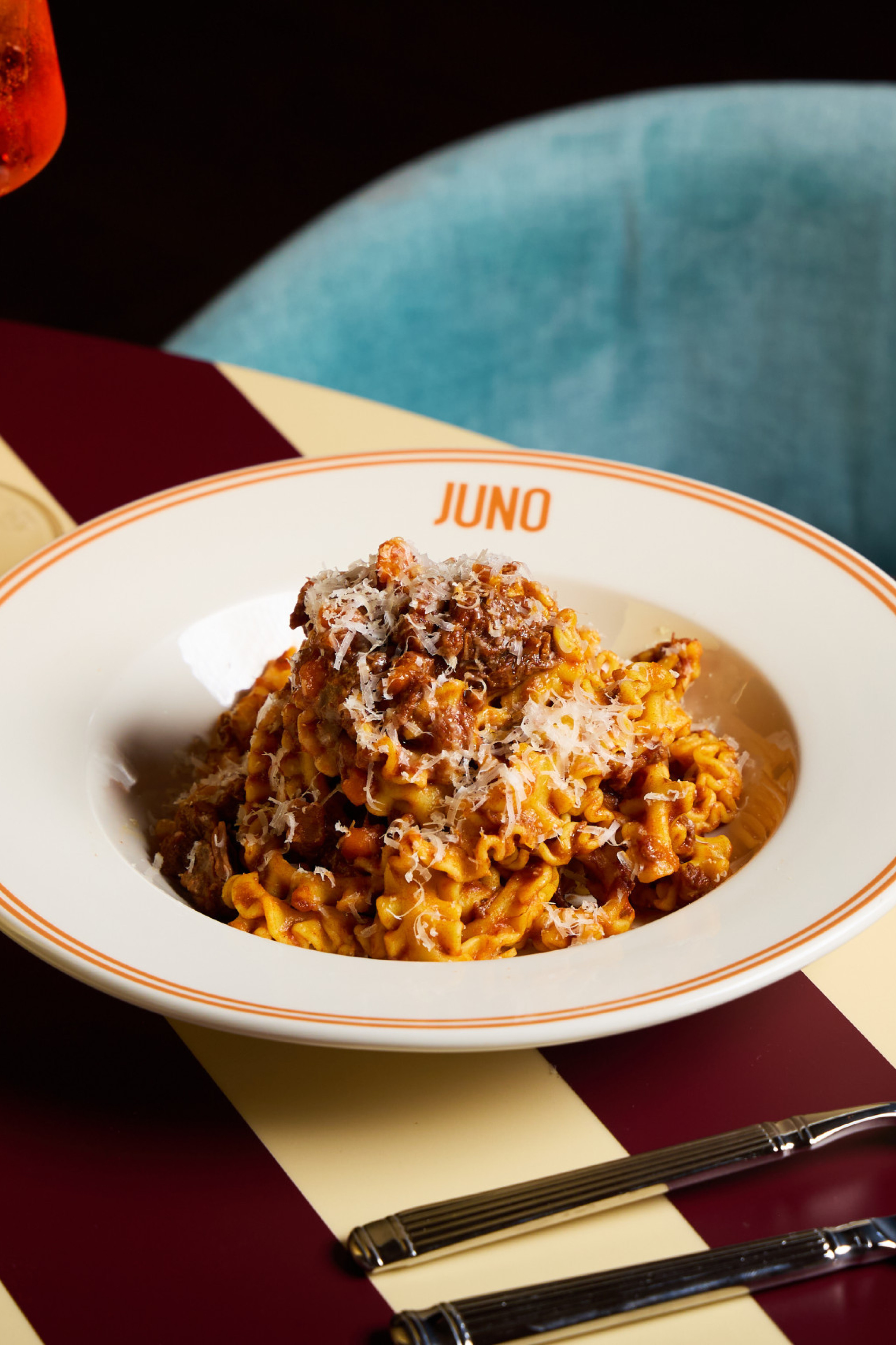 bowl of pasta on striped table at JUNO London
