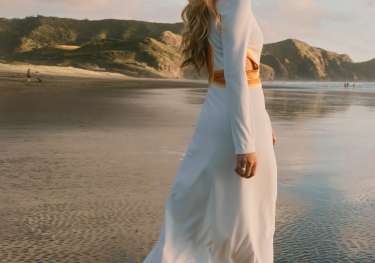 Woman walking along beach.