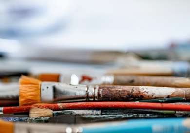 Paint brushes stacked on flat surface.