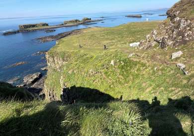 People trekking on lunga in hebrides.