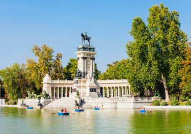  madrid park with lake dotted with boats .