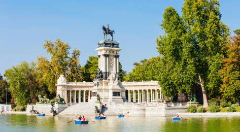  madrid park with lake dotted with boats .