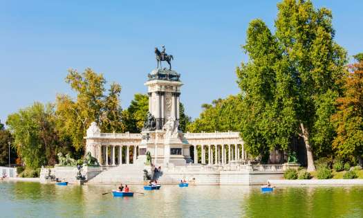  madrid park with lake dotted with boats .