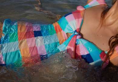 Model posing in colourful check swimsuit.
