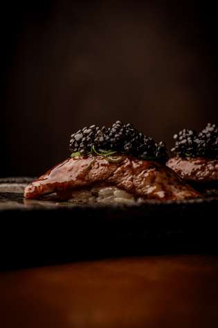 Meat dish topped with blackberries .