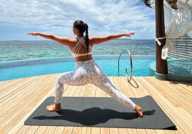 Woman doing yoga in the maldives.