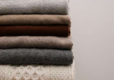 Stack of jumpers in neutral colours.