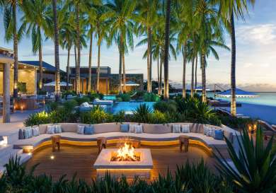 Beach club in the evening with palm trees in the distance .