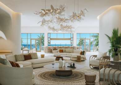 Lounge area at hotel with cream sofas and wooden chairs .