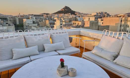 Hotel rooftop area with round table and chairs.