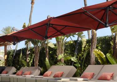Hotel pool with sunbeds around the edge.