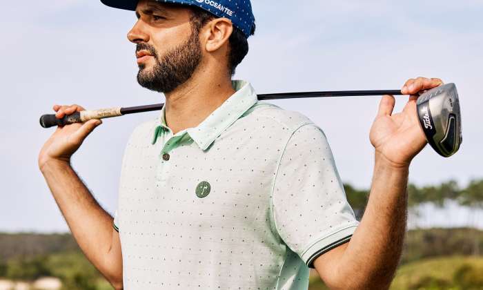 Oceantee man holding golf club on golf course .