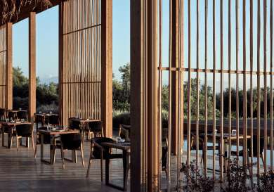 View of tables inside greek hotel restaurant .