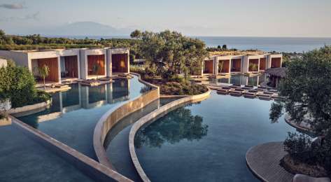 Photo of tiered pools at greek hotel .