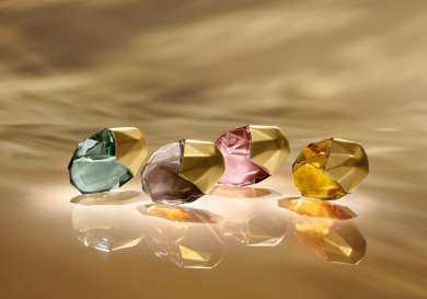 Lifestyle image of four perfume bottles lying on their sides .