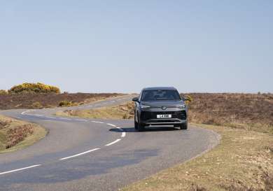 SUV car driving around bend.
