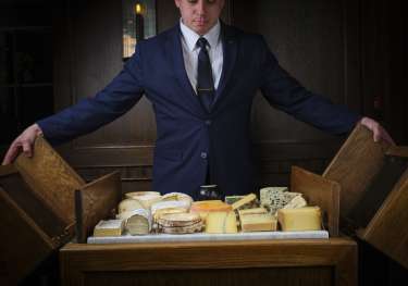 Person opening cheese board at Ormer restaurant .