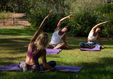 Three people doing yoga outside.