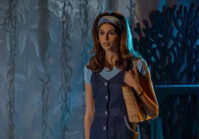 Kaia gerber on set of palm royale in blue outfit and big hair.