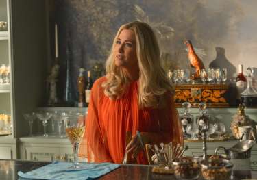 Kristen wiig on set of palm royale in orange dress.