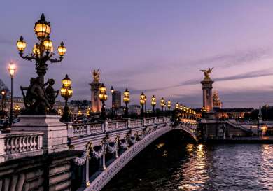 Photo of bridge in paris in the evening with lights.