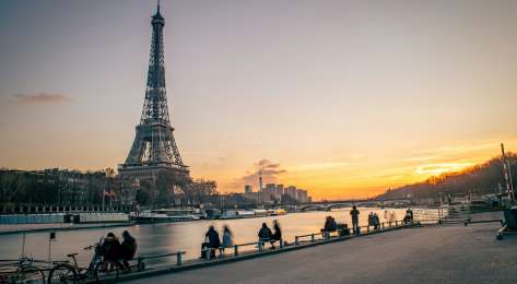 Photo of eiffel tower next to the seine.