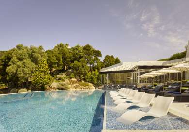 Outdoor hotel swimming pool with sunken sunbeds.
