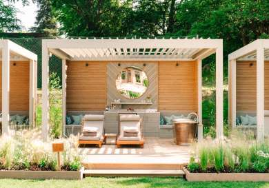 Outdoor decking area with roll-top bath and lounge chairs .