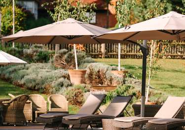 Hotel pool with umbrellas and deckchairs.