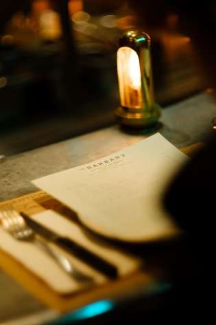 Photo of someone looking at menu at barbary restaurant .