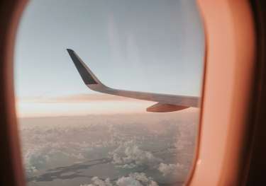 View through plane window with clouds .