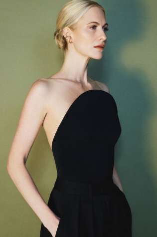 Poppy delevingne modelling jewellery in black top and trousers .