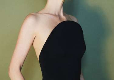 Poppy delevingne modelling jewellery in black top and trousers .