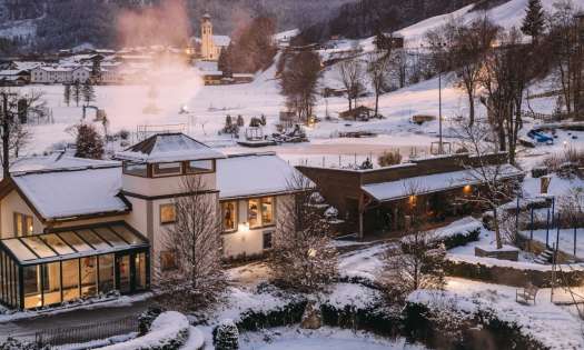 Aerial view of hotel pool with snowy hills in the background .