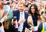 Prince harry and meghan greeting crowds of wellwishers in australia.