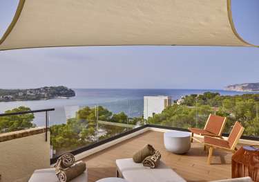 View of terrace in hotel room with sea view.