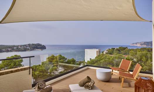 View of terrace in hotel room with sea view.
