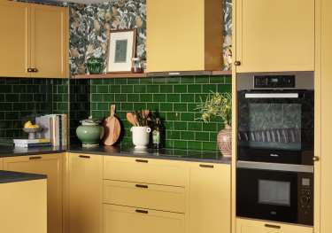 Kitchen with butter yellow cabinets and check flooring.