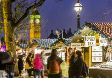 Stalls decorated with lights and garlands offer goods like 