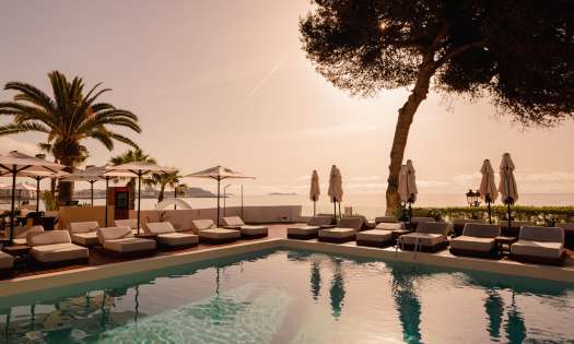 Hotel riomar ibiza swimming pool with lounge beds and parasols .