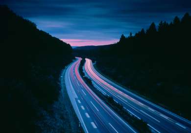 Road at night with light trail.