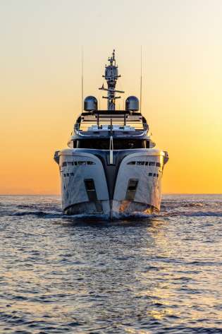 Photo of yacht sailing at sunset .