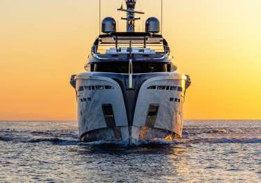 Photo of yacht sailing at sunset .