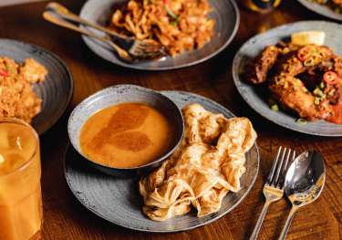 Spread of food on table from Roti King restaurant .