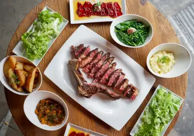 Meat dish and side dishes at sagardi restaurant.