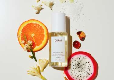 Ouai hair mist surrounded by slices of orange and dragon fruit.