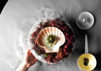 Scallop dish being served on round table.