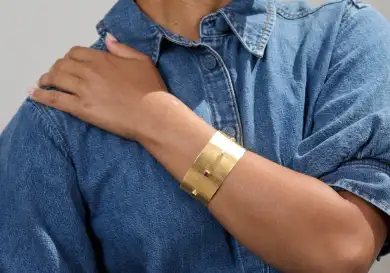 Model wearing gold bangle.