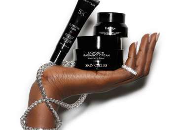 Model holding three beauty products in hand with diamond jewellery.